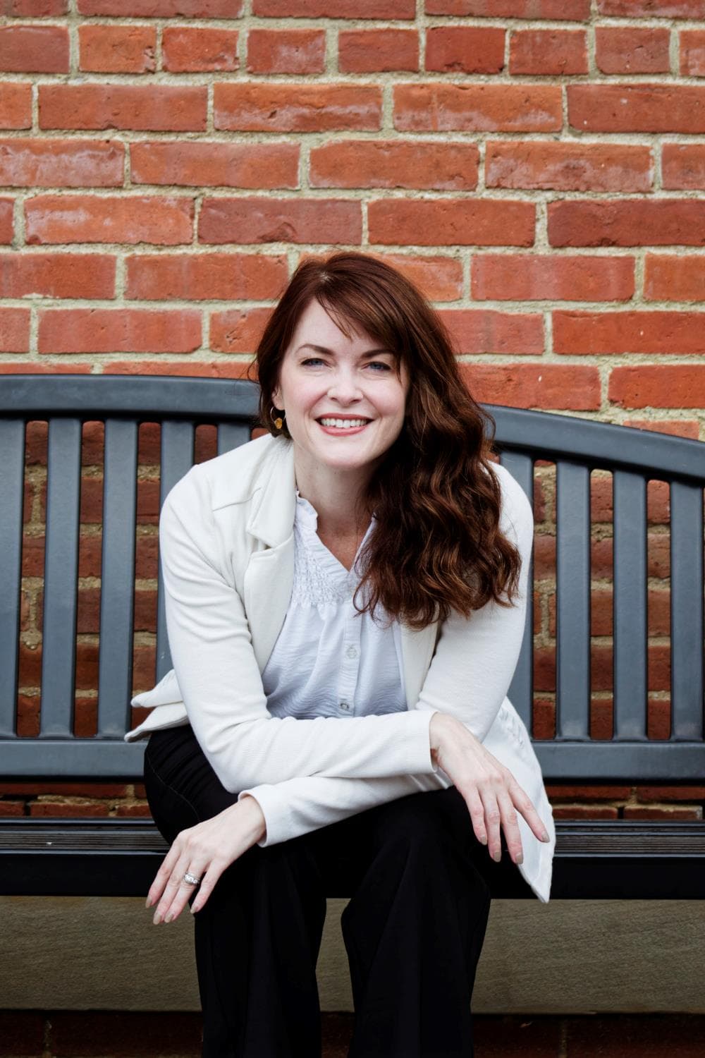 Headshot Sitting on a Bench with Brick Background